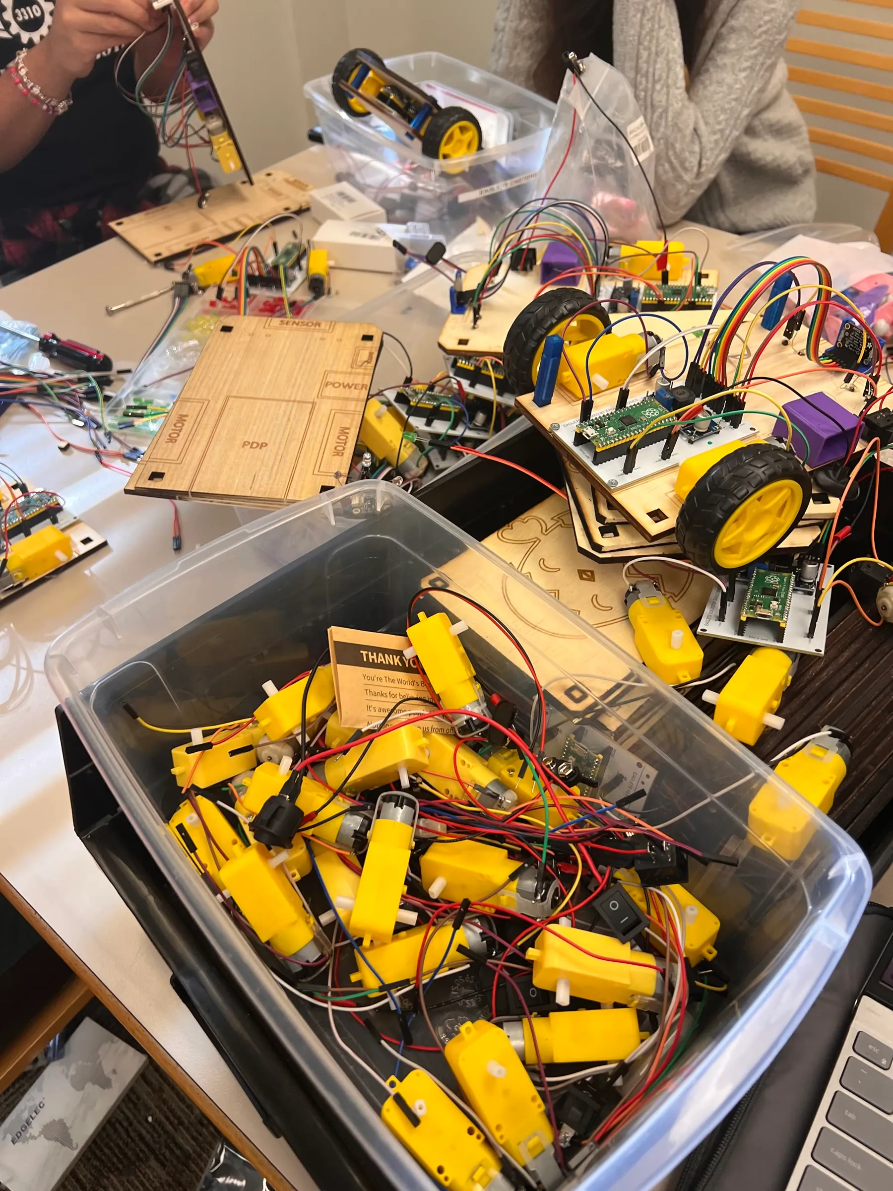 A worktable covered with Eaglets robot parts, assembled kits, motors, and wiring.
